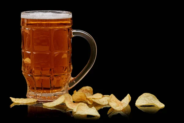 Glas bier mok met aardappel chips geïsoleerd op zwarte achtergrond. — Stockfoto