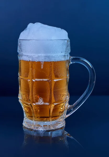 Glas bier mok met schuim geïsoleerd op donkere achtergrond. — Stockfoto