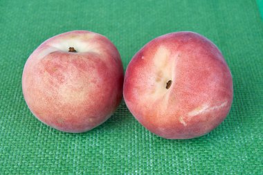 Olgun lezzetli şeftali meyve yeşil hasır kumaş üzerine