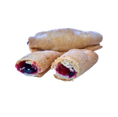 Kiraz ve izole beyaz bir arka plan üzerinde siyah kuş üzümü ile çerezleri haddelenmiş. Şekerli tatlı.