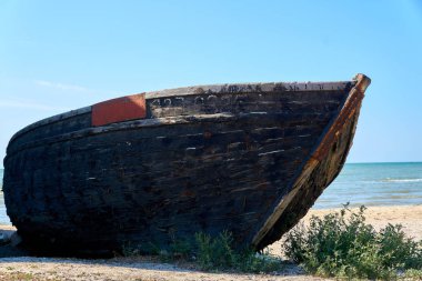 Ahşap balıkçı teknesi paslı çivi ile deniz kenarında terk edilmiş