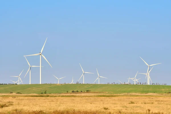 Wind turbines generating electricity on blue sky background - th