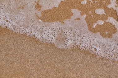 Arka plan olarak kumlu plajda denizin dalga yumuşak.