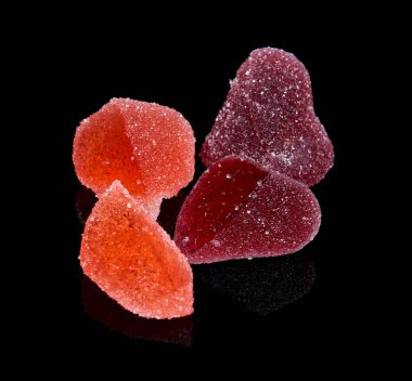 Marmelat siyah bir arka plan üzerinde izole kalp şeklinde parçaları.