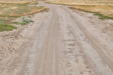 Ot kurutma ile bozkır geçiş kırsal kirli tozlu ve dolambaçlı yol.