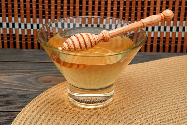 Мед з медоносцями на скляній тарілці ізольовані на чорному тлі — стокове фото