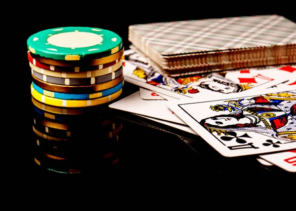 Pokerchips und Karten isoliert auf schwarzem Hintergrund. — Stockfoto
