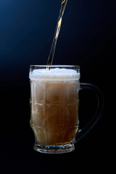 Glas bier mok met schuim geïsoleerd op donkere achtergrond. — Stockfoto