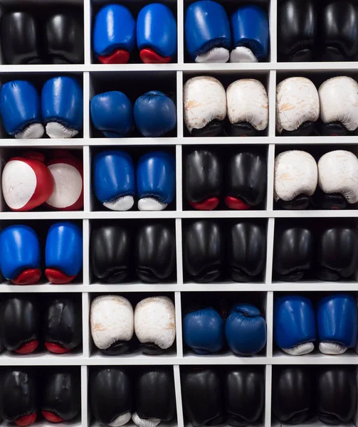 A picture of collection of boxing gloves on the shelve. Perfect for promotion of boxing and fitness.