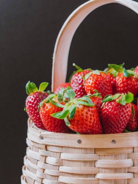 Taze topalmış çilek ahşap sepet. Siyah arka plan