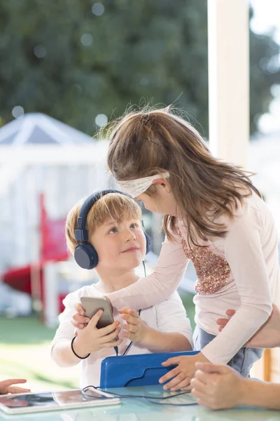 Dos Niños Pequeños Sosteniendo Teléfono Inteligente Niño Usando Auriculares —  Fotos de Stock
