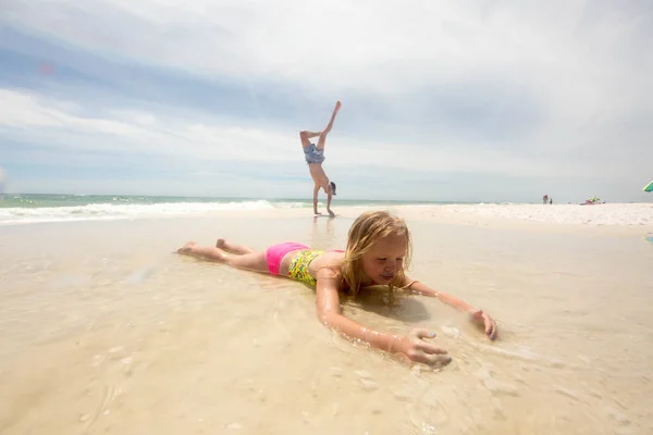 Girl Lying Beach Shallow Water Brother Doing Handstand Background — Stock Photo, Image