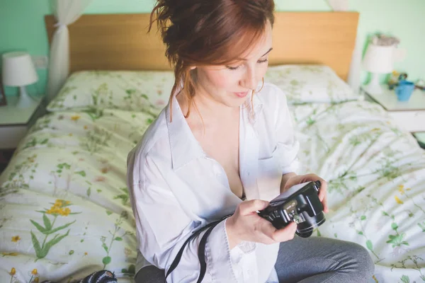 Junge Frau Sitzt Auf Dem Bett Und Überprüft Digitalkamera — Stockfoto