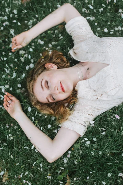 Woman Lying Blossom Covered Grass Overhead View — Stock Photo, Image