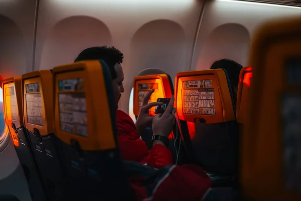 Över Axeln Syn Mannen Sitter Passagerarplan Med Hjälp Mobiltelefon — Stockfoto