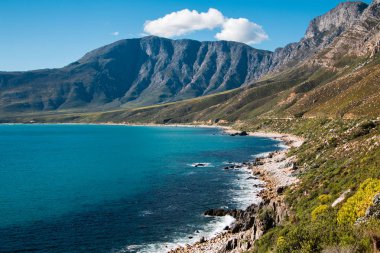Deniz ve dağlar, mavi gökyüzü ve bulutlar Cape Town Güney Afrika kıyısındaki manzara.