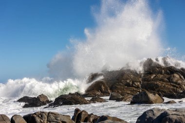 Büyük Okyanus Dalgası Kayaya Karşı Çarpıyor Deniz 'in Dramatik Su Sıçratma Gücü Açık Mavi Gökyüzü ve Rocky Sahil Hattı altında