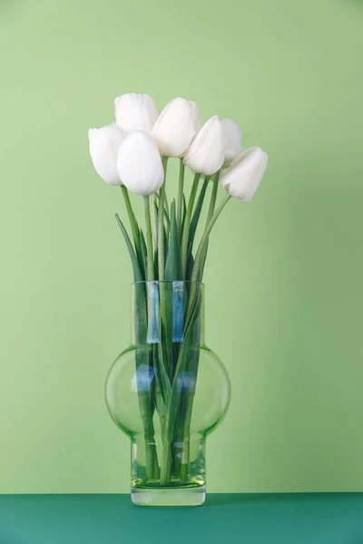 Белые тюльпаны в вазе на зеленом фоне . — стоковое фото