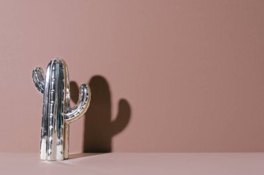 Bej renkli arka plan üzerinde yaratıcı altın kaktüs.