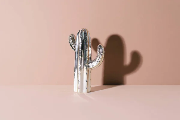 Creatieve gouden cactus op beige achtergrond. — Stockfoto