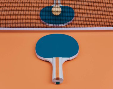 Masa tenisi veya ping pong raketleri ve topları turuncu masa.