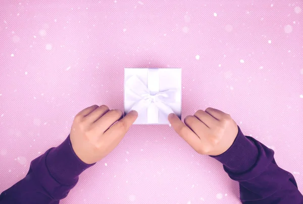 Hände, die eine kleine Schachtel mit einem Geschenk halten. — Stockfoto