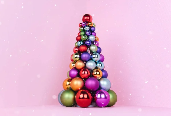 Noel ağacı topu dekorasyon pembe bir arka plan üzerinde yapılan. — Stok fotoğraf