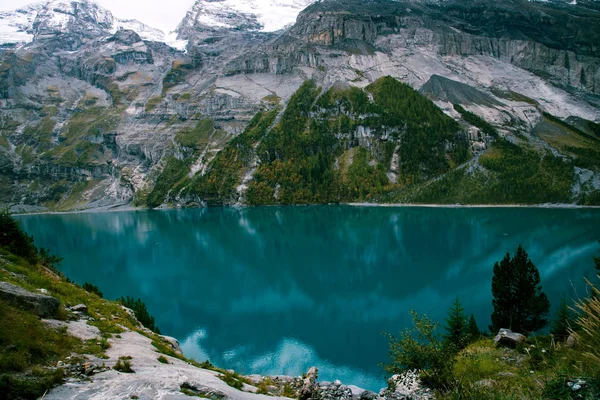 Vue sur le lac Oeschinen dans les Alpes suisses avec une belle eau turquoise . — Photo