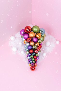 Noel ağacı topu dekorasyon pembe bir arka plan üzerinde yapılan.