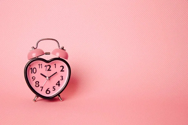 Szív alakú óra rózsaszín háttér. — Stock Fotó