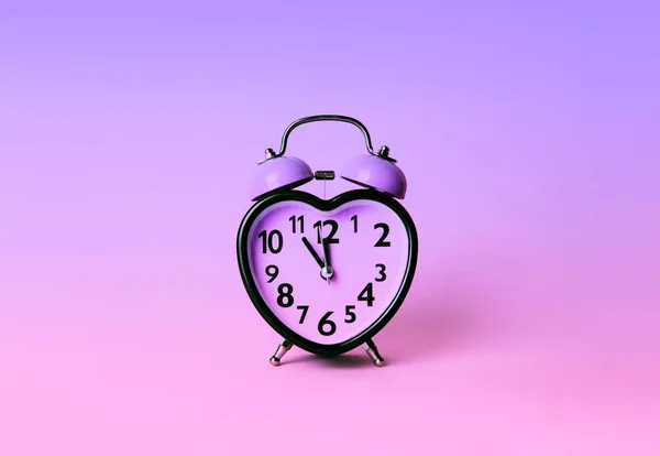 Годинник у формі серця на рожевому фоні . — стокове фото