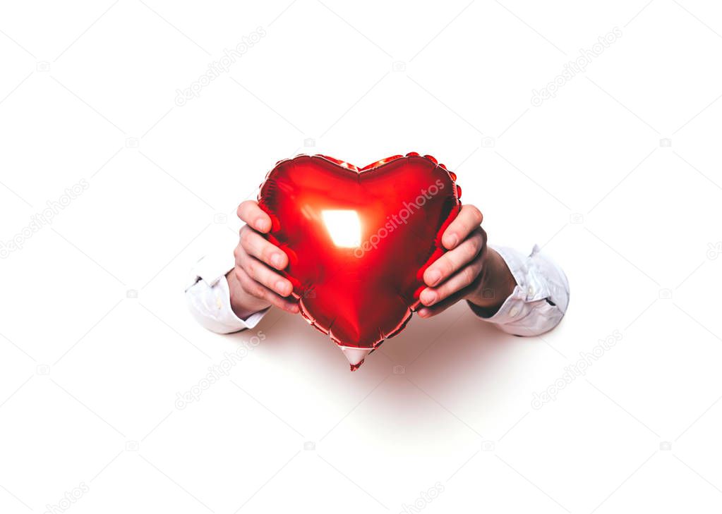 Hands holding a heart on white background.