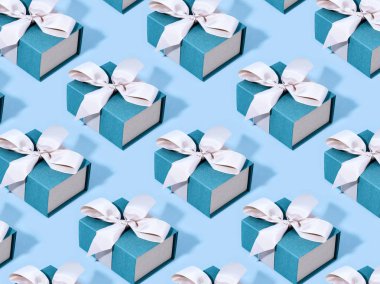 Mavi hediye kutuları pastel arka plan üzerinde desen yapılmış.