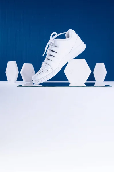 Paire de baskets blanches sur fond bleu et blanc . — Photo