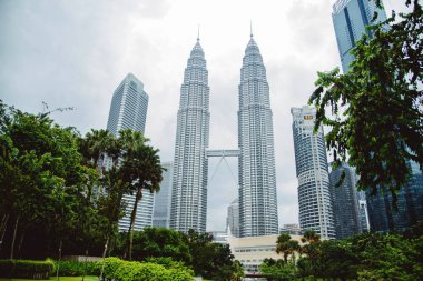 Kuala Lumpur'da. Altın-mavi ışıkta Petronas İkiz kuleleri ve komşu gökdelenler.