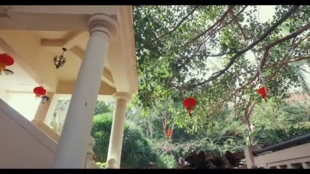 Beau jardin tropical dans l'hôtel. Bâtiment avec colonnes et lanternes rouges. Hôtel en Chine, Sanya . — Video