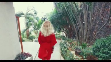 Kırmızı elbiseli sarı saçlı Genç bir kızla otelde taş merdivenle iner. Her tarafında palmiye ağaçları vardır. Kamera bir steadicam ile hareket ediyor. Çin'deki otel.