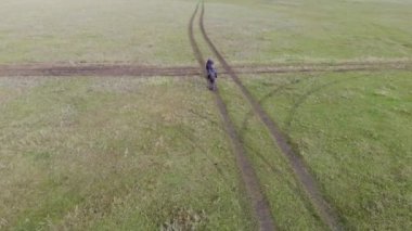 A boy and a girl are running around the field. Little children have fun in nature in the spring.
