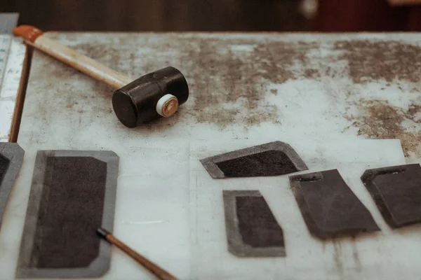 Δερμάτινη craftmans επιφάνεια εργασίας. Κομμάτια από δέρμα και εργαλεία εργασίας σε ένα τραπέζι εργασίας. Τέχνη δέρμα. — Φωτογραφία Αρχείου