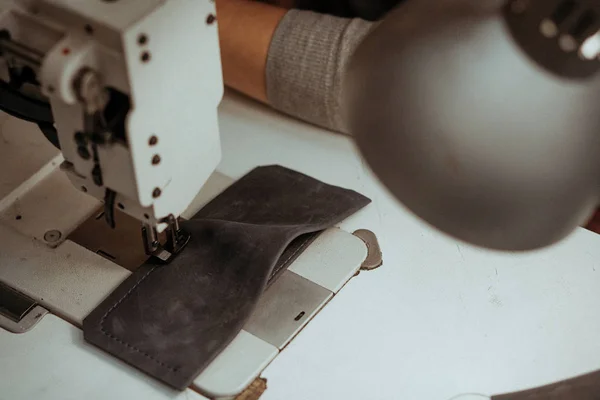 Close-up bir dikiş makinesi atölye masada yatan deri parçası. El yapımı şablonu'nda yerel atölye çalışmalarında. — Stok fotoğraf
