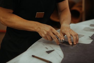 Adam holding işçiliği aracı ve çalışma. Deri Tekstil ile araçlarını kullanarak onun atölyesinde çalışan bir ustanın kapatın. El yapımı kavramı.