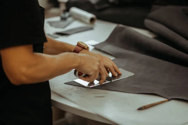 Deri araçlarını kullanarak onun laboratuarda çalışan bir esnaf, yakın çekim. El yapımı kavramı. Adam holding işçiliği aracı ve çalışma.