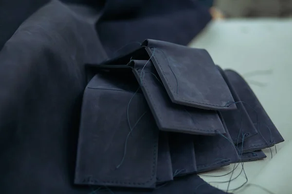 Кусочки кожи и подготовка бумажников на столе в мастерской. Кожаный бумажник ручной работы . — стоковое фото