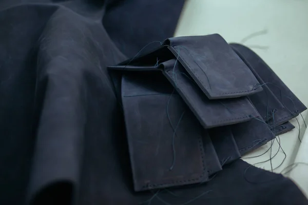 Кусочки кожи и подготовка бумажников на столе в мастерской. Кожаный бумажник ручной работы . — стоковое фото