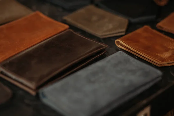 Colored leather passport covers and wallets on the table. Black background. Handmade concept.