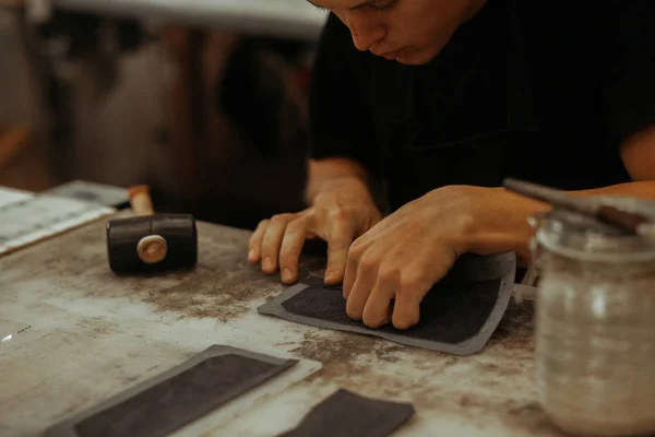 Primer plano de artesano de cuero que trabaja con cuero natural. Maestro hecho a mano en el trabajo en taller local. Concepto hecho a mano . —  Fotos de Stock