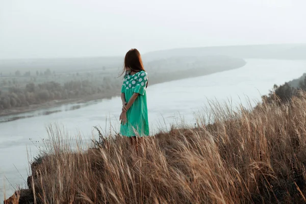 Unga kvinnor i klänning på sluttningen av floden — Stockfoto