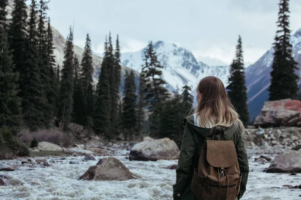Dağ nehri ve kayalara bakan genç kadın — Stok fotoğraf