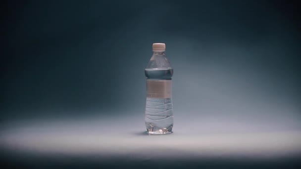 В лаборатории ученый ставит бутылку воды на свет — стоковое видео