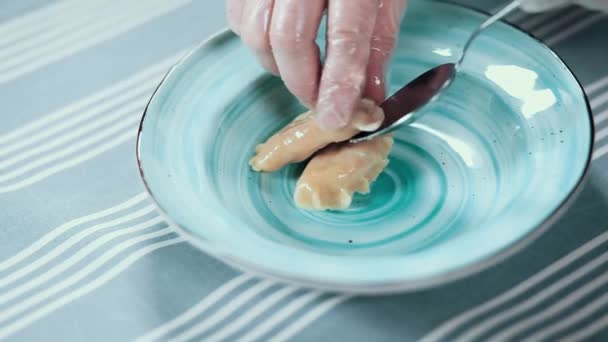 Hände geben Essen ab und gießen Suppe in blauen Teller — Stockvideo